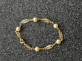 
															Bracelet or et perles
														